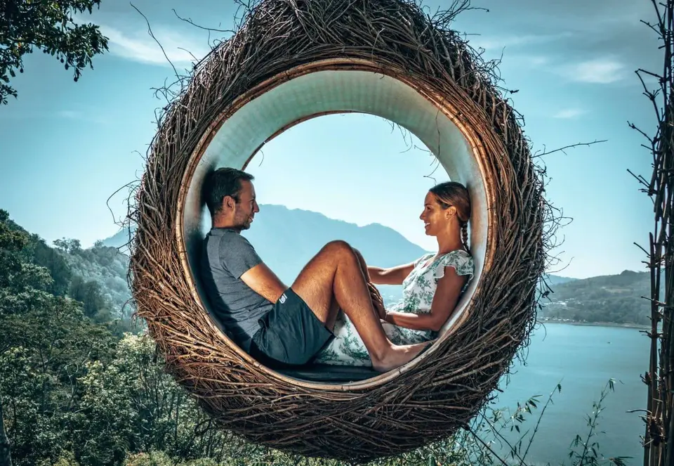 James and Lee sitting in a giant woven nest at Wanagiri Hidden Hills, Bali