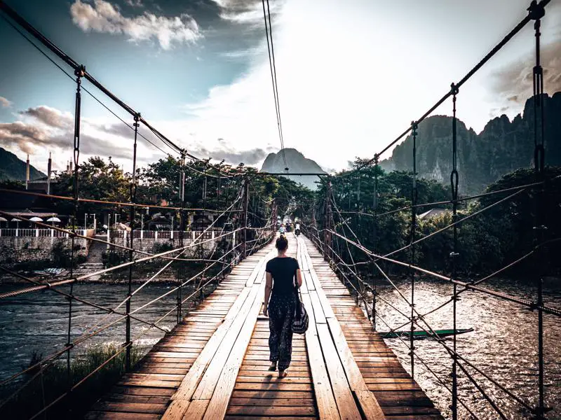 Picture of girl crossing Nam Song bamboo bridge to Vang Vieng viewpoint Laos