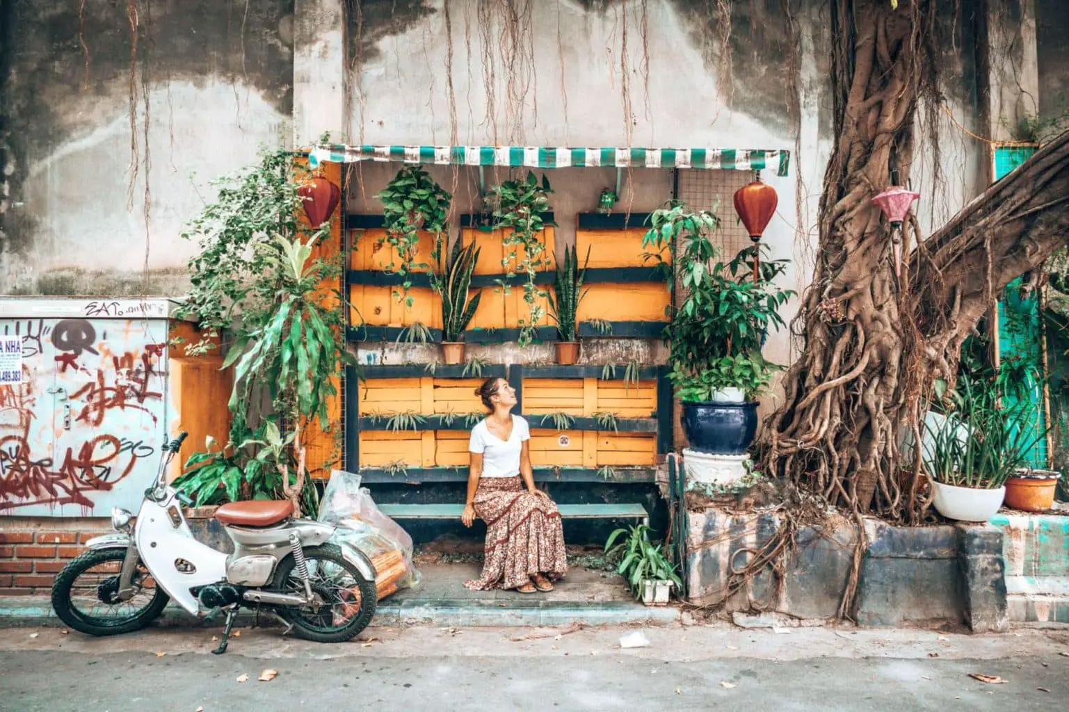 Picture of girl sitting at a photo wall in Hanoi Vietnam